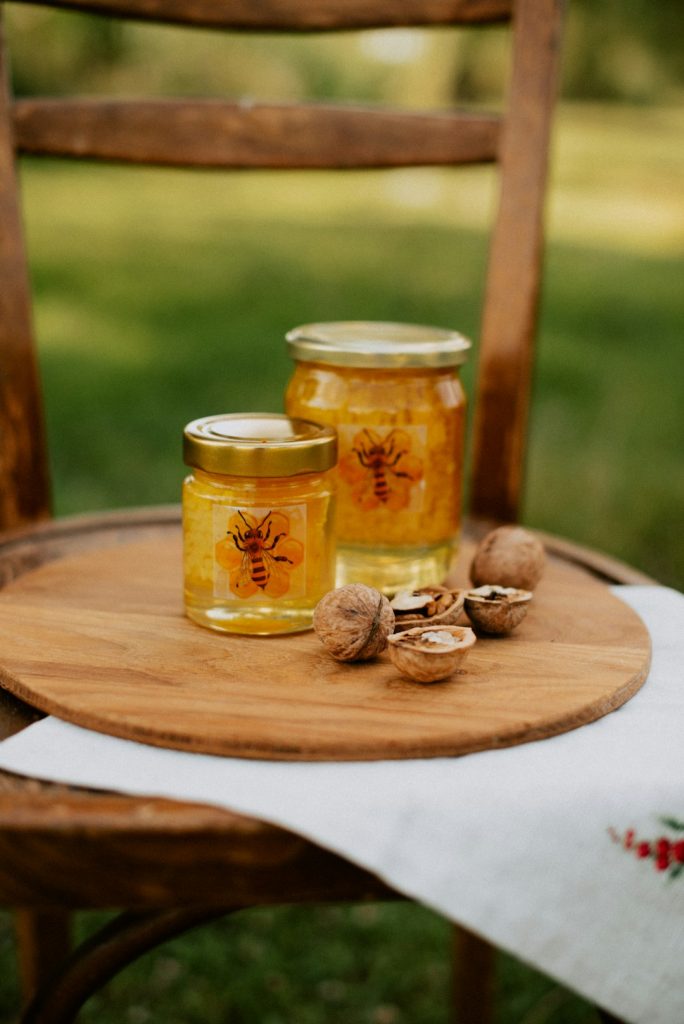 two-jars-of-honey-sit-on-a-wooden-table-3e4kg8rb4y8